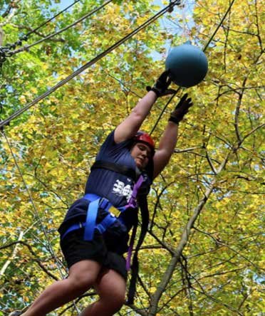 student on zipline in forest