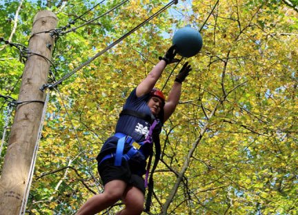 student on zipline in forest