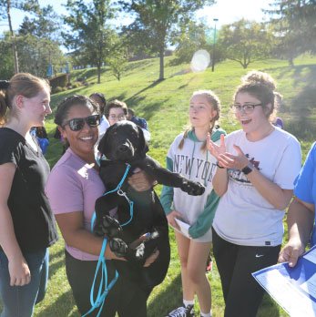students holding a puppy